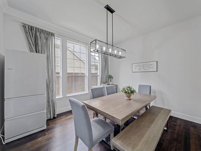 Dining room with baseboards, dark wood-style flooring, and a chandelier | Image 4