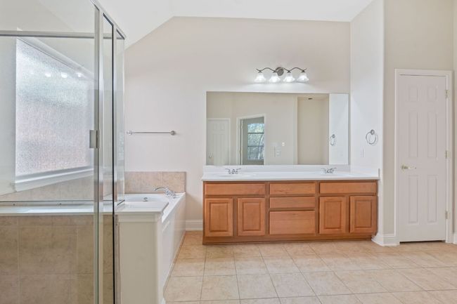 Full bath featuring a bath, a sink, tile patterned flooring, and a shower stall | Image 22