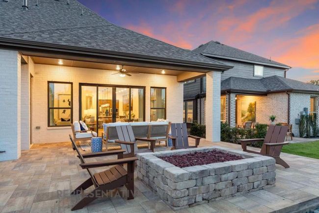Back of property at dusk with a patio area, ceiling fan, brick siding, and roof with shingles | Image 39