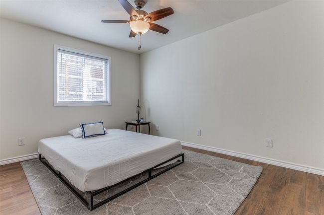 Bedroom with baseboards, wood finished floors, and a ceiling fan | Image 10