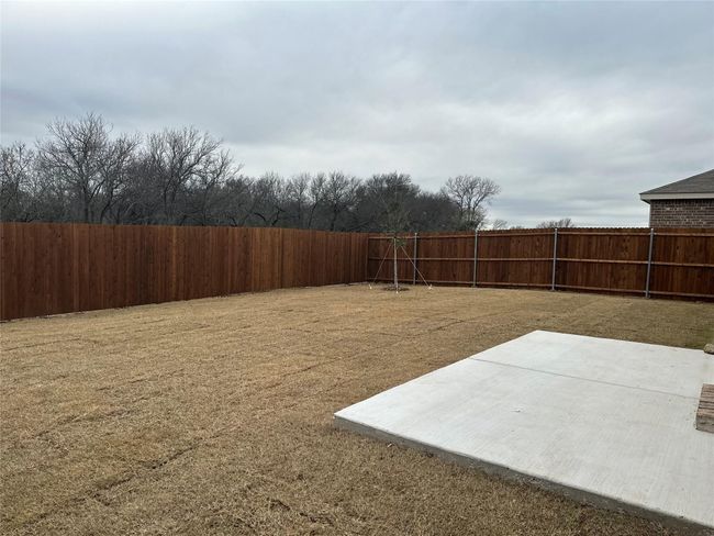 Fenced backyard with a patio | Image 14