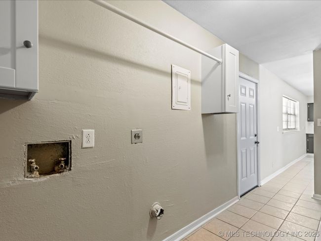 Laundry room with cabinets and hanging rod | Image 10