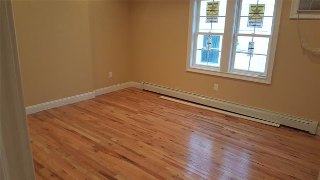 Spare room with a baseboard heating unit, a wall mounted AC, and light hardwood / wood-style flooring | Image 5