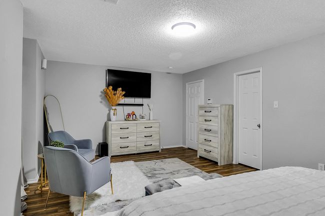 Bedroom featuring baseboards, dark wood-style flooring, and a textured ceiling | Image 8