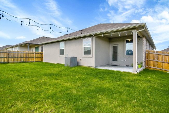 Back of property with stucco siding, a patio area, and cooling unit | Image 31