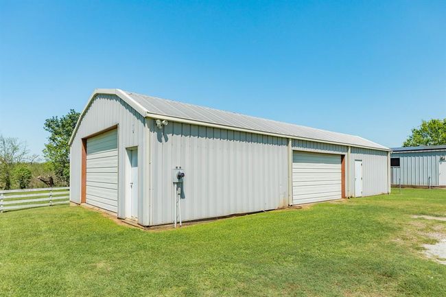 The walk-in door to the right of this building goes into an unfinished a large unfinished storage room. | Image 47