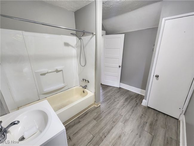 Bathroom with lofted ceiling, hardwood / wood-style floors, a textured ceiling, and shower combination | Image 15