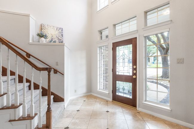 Entryway with plenty of natural light, light tile patterned floors, baseboards, stairs, and a high ceiling | Image 36