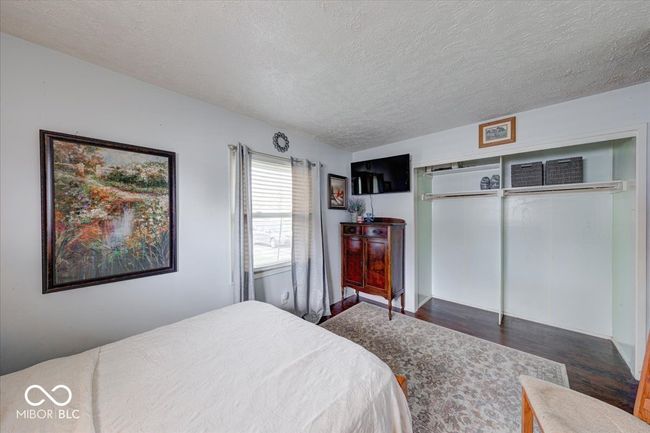 bedroom #2 featuring a textured ceiling, wood finished floors, and a great closet | Image 32