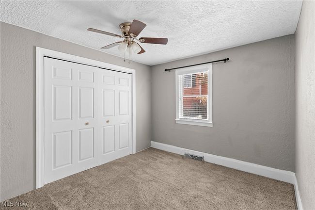 Unfurnished bedroom with a closet, carpet flooring, a textured ceiling, visible vents, and a textured wall | Image 13
