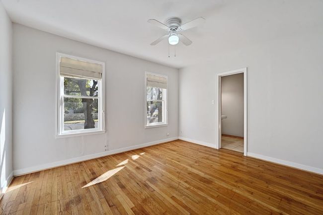 Unfurnished room with a ceiling fan, baseboards, and light wood finished floors | Image 12