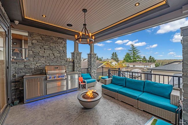 View of patio with a grill, an outdoor kitchen, and an outdoor living space with a fire pit | Image 11