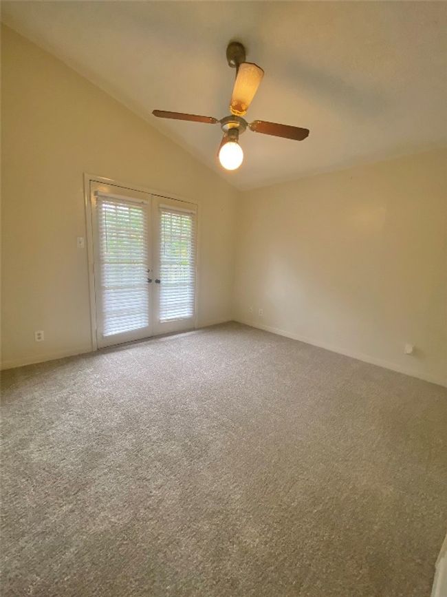 Carpeted spare room featuring baseboards, a ceiling fan, french doors, and lofted ceiling | Image 20