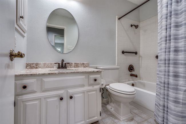 Full bath with vanity, shower / bath combination with curtain, and tile patterned floors | Image 19