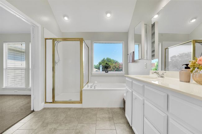 Bathroom with a garden tub, a shower stall, vanity, and lofted ceiling | Image 31