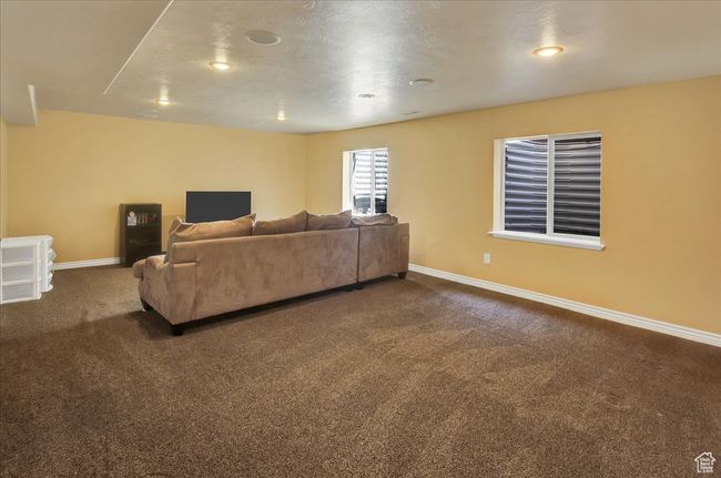 Living area with recessed lighting, dark colored carpet, and baseboards | Image 22