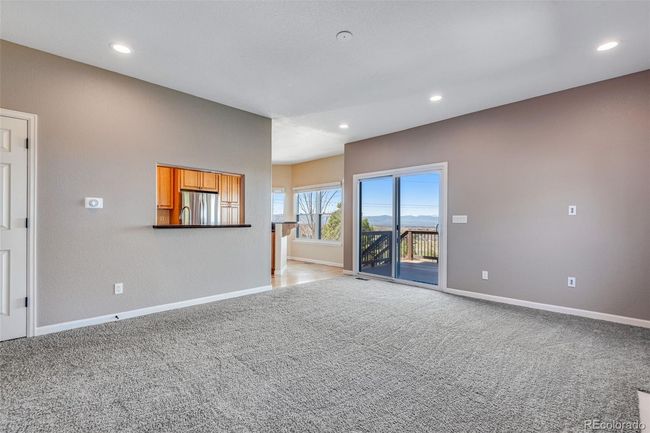 Unfurnished living room with light colored carpet, baseboards, and recessed lighting | Image 11