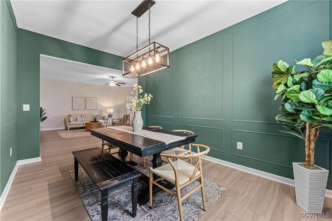 Dining room featuring a decorative wall, light wood-type flooring, baseboards, and ceiling fan | Image 4