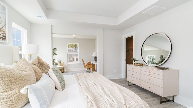 Bedroom with light wood-type flooring, a tray ceiling, and baseboards | Image 18