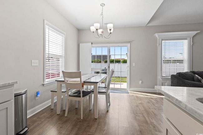 Dining area featuring baseboards, wood finished floors, and a notable chandelier | Image 17