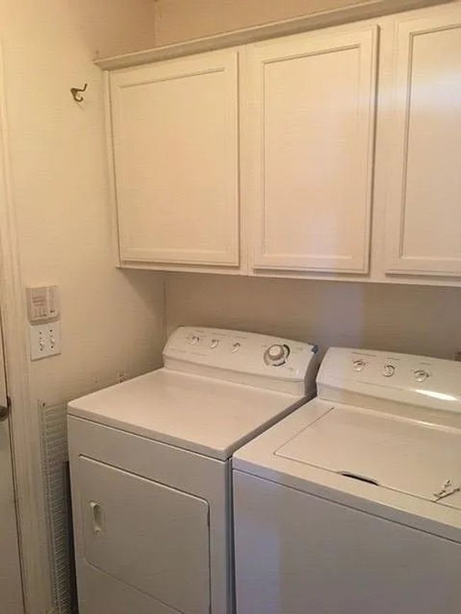 Laundry area featuring washer and clothes dryer and cabinet space | Image 17