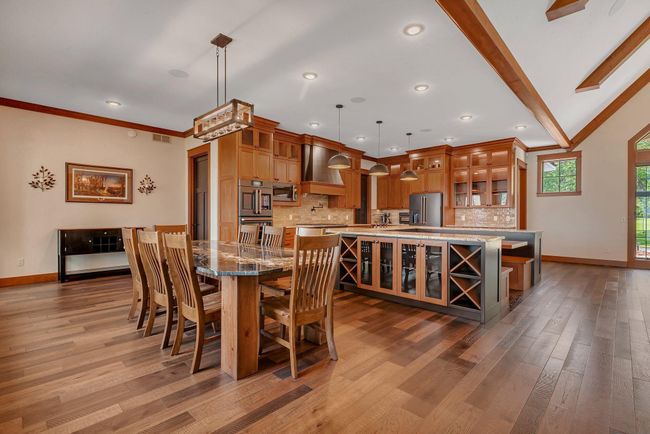 Kitchen dining area featuring spacious seating and a beautiful granite countertop, perfect for family meals or entertaining guests. | Image 44
