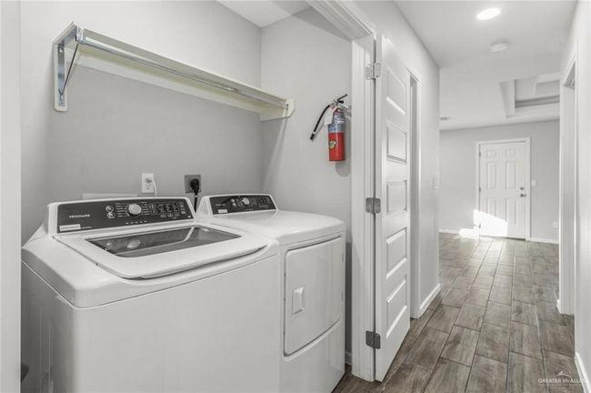 Washroom with washer and dryer, wood finished floors, baseboards, and recessed lighting | Image 7