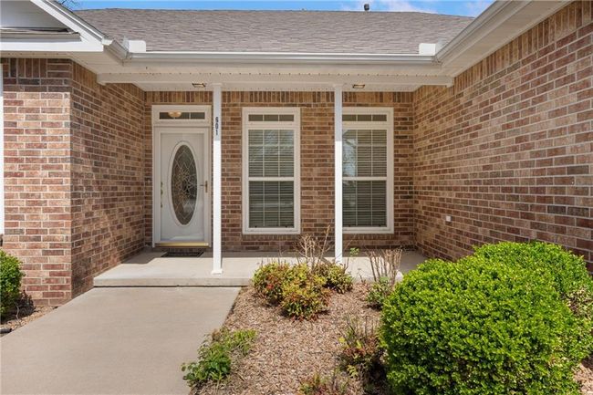 View of exterior entry with brick siding and a shingled roof | Image 6