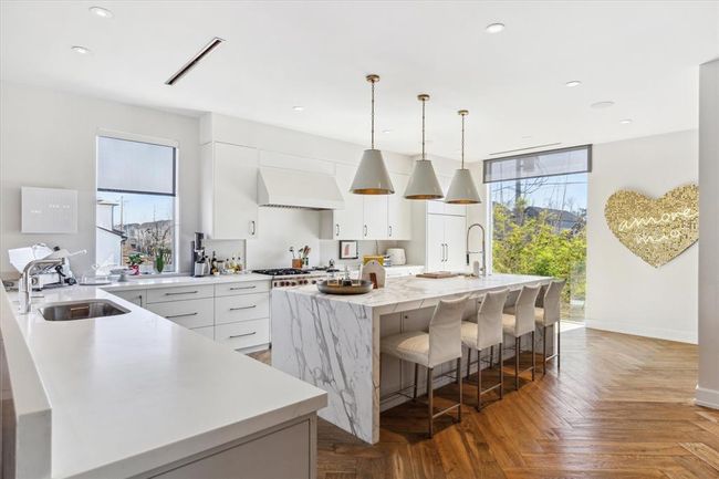2019 Du Barry’s kitchen centers around a stunning honed gold Carrara marble waterfall island, beautifully accented by Circa decorative lighting. With seating designed for conversation, coffee, or cocktails, it’s the perfect place for guests or the family to gather and unwind in the heart of the home. | Image 10