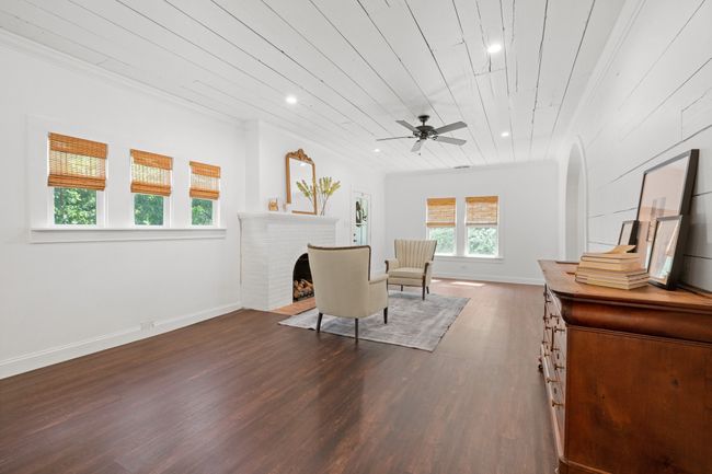 Sitting room with dark wood-type flooring, ceiling fan, recessed lighting, a fireplace, and ornamental molding | Image 7