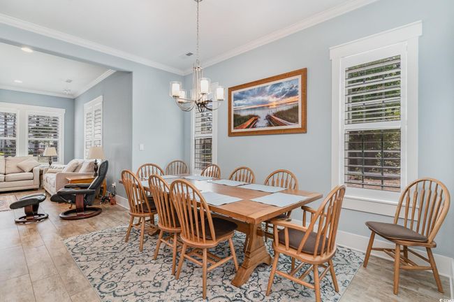 Dining space with ornamental molding, baseboards, a notable chandelier, and light wood finished floors | Image 13
