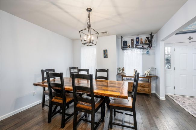 Dining space with a notable chandelier, dark hardwood / wood-style flooring, and a baseboard heating unit | Image 10