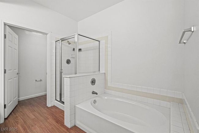 The sequestered primary suite is a true retreat, offering a large walk-in closet and a spa-inspired en suite bath with dual vanities, a soaking tub, and a separate walk-in shower. | Image 22