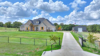 View of front facade with an outdoor structure, a garage, a front yard, and a rural view | Image 1