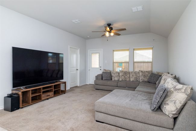Living room with a ceiling fan, carpet flooring, and vaulted ceiling | Image 17
