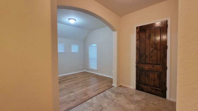 Entrance foyer featuring arched walkways, vaulted ceiling, baseboards, and wood finished floors | Image 6