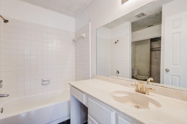 Full bathroom featuring toilet, vanity, shower combination, and a textured ceiling | Image 13