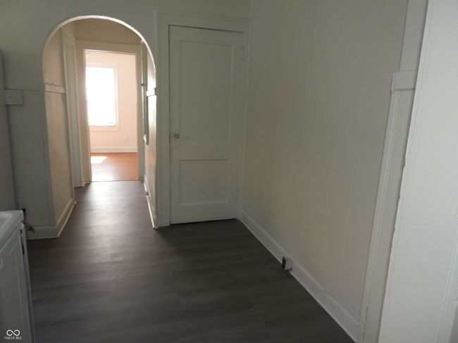 hall featuring dark wood-style floors, arched walkways, and baseboards | Image 5