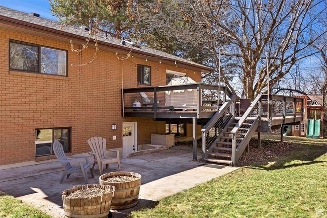 Rear view of property with a patio area, brick siding, a wooden deck, and a lawn | Image 33