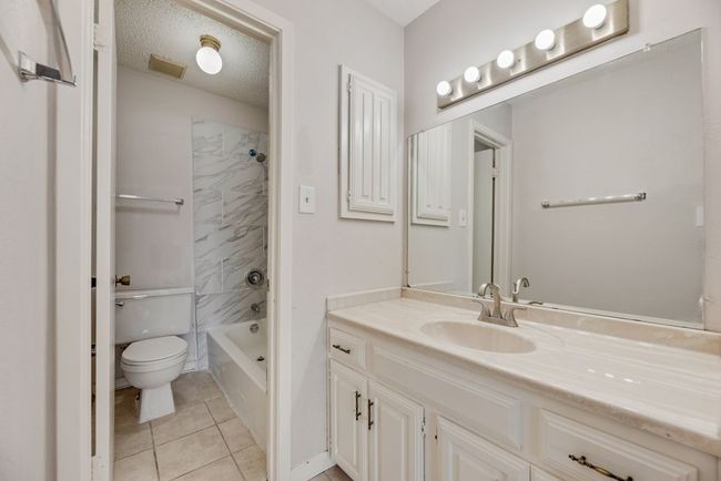 Bathroom with vanity, tile patterned floors, and washtub / shower combination | Image 16