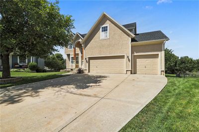 View of front facade with a garage and a front yard | Image 2