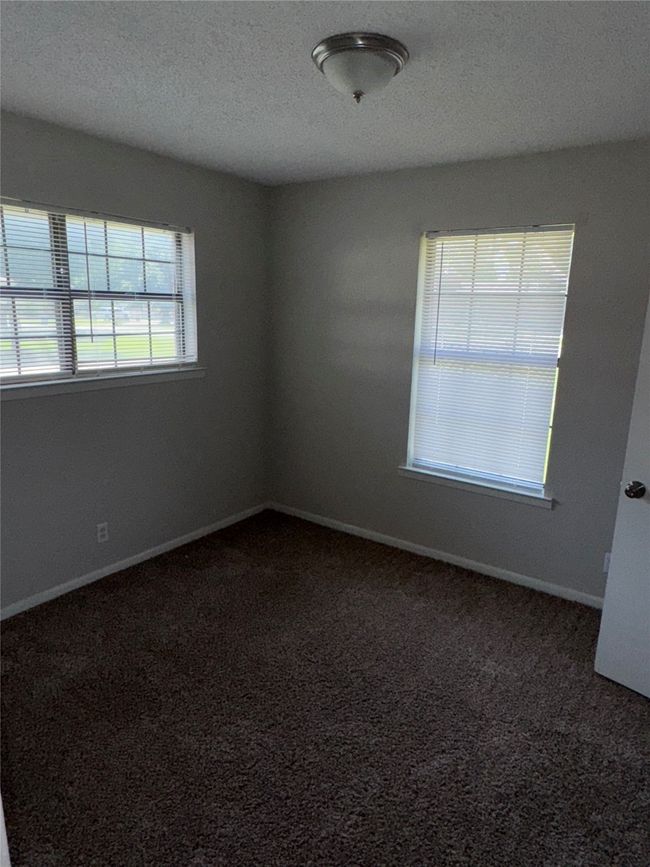 Empty room with carpet flooring, baseboards, and a textured ceiling | Image 10