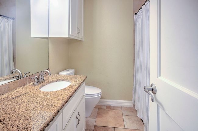 Bathroom with baseboards, toilet, vanity, and tile floors | Image 37