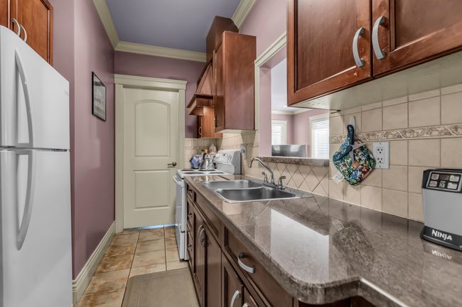 Kitchen featuring white appliances, a sink, ornamental molding, tasteful backsplash, and baseboards | Image 17
