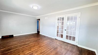 Empty room featuring ornamental molding, french doors, and dark hardwood / wood-style flooring | Image 3