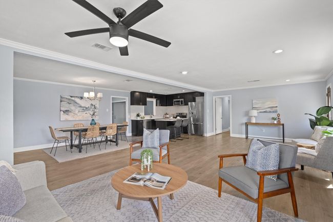 Living room featuring light wood-type flooring, baseboards, visible vents, and ornamental molding | Image 10
