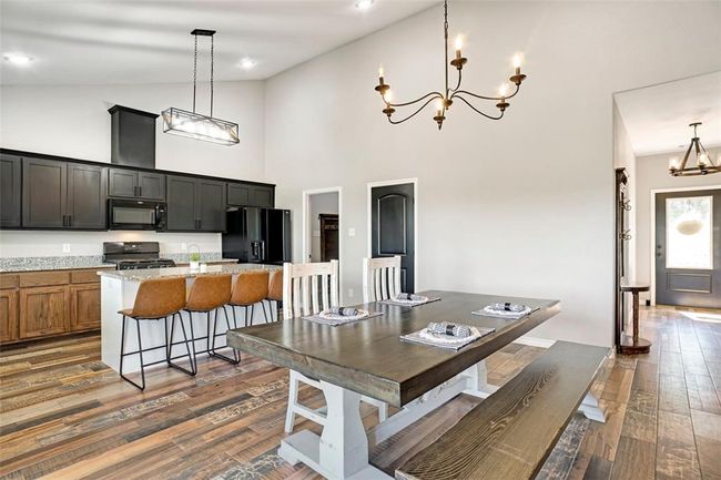 Dining room featuring high vaulted ceiling, a chandelier, and dark hardwood / wood-style floors | Image 11