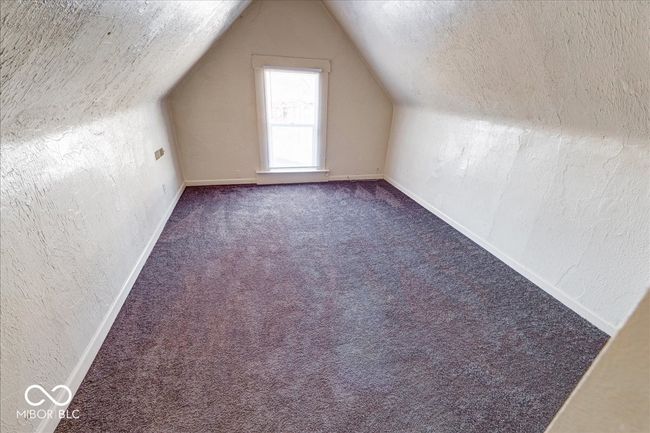 additional living space with baseboards, carpet, a textured wall, and vaulted ceiling | Image 21