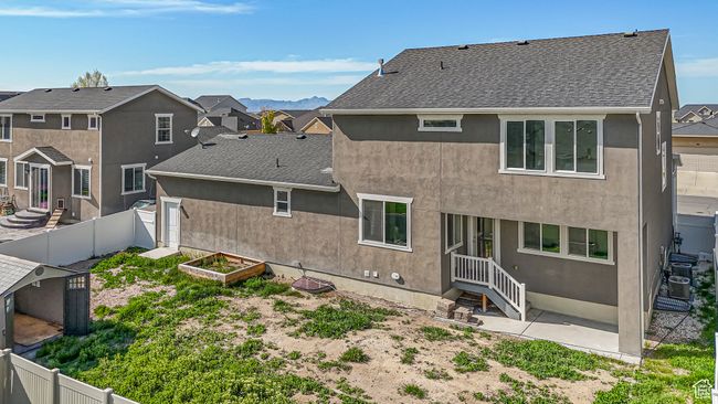 Rear view of property featuring a garden, a fenced backyard, and roof with shingles | Image 42