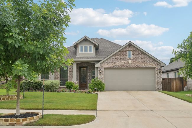 View of front of house featuring brick siding, a garage, driveway, and a shingled roof | Image 40